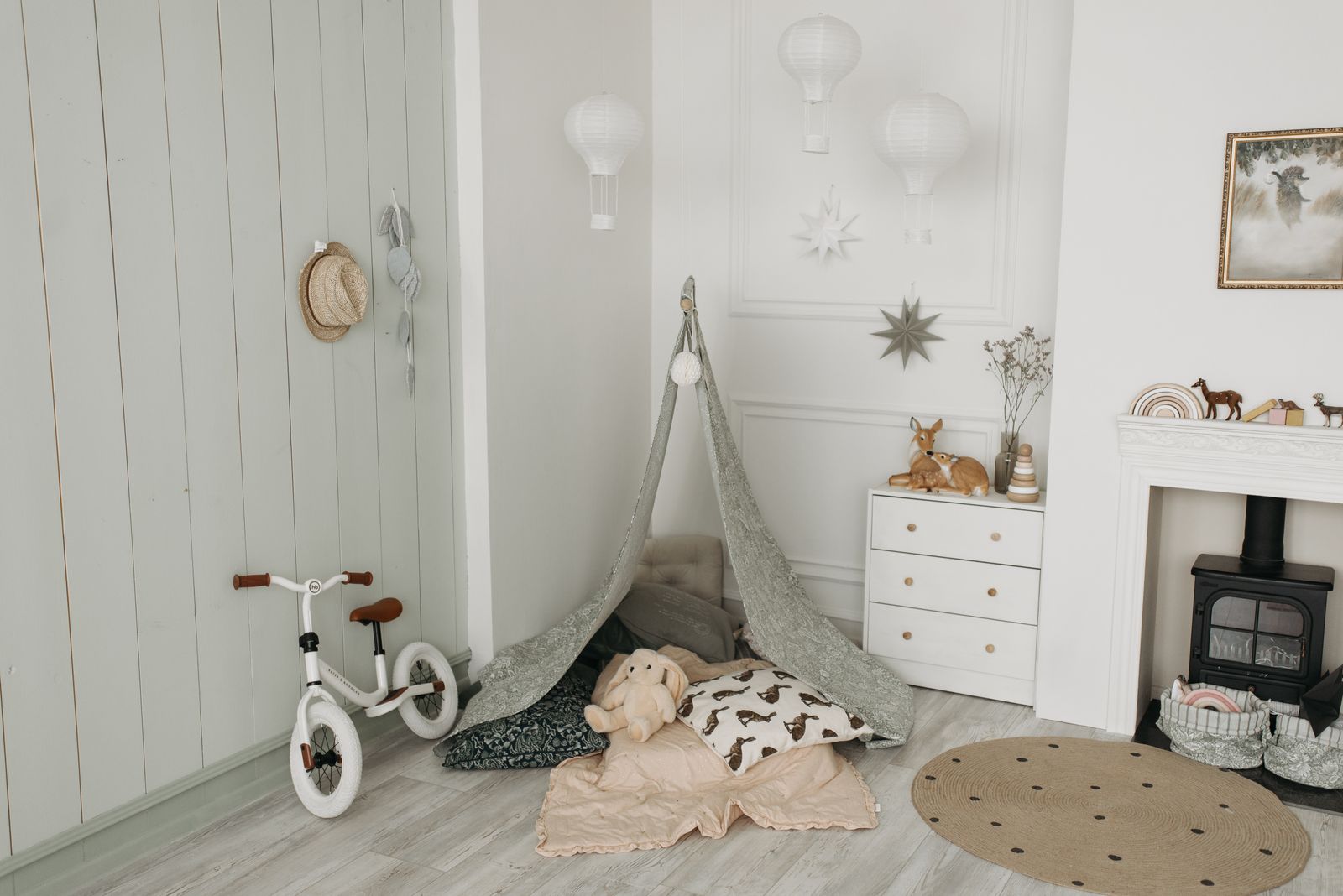 A bright, tidy playroom with soft seating, low shelves and a cosy corner