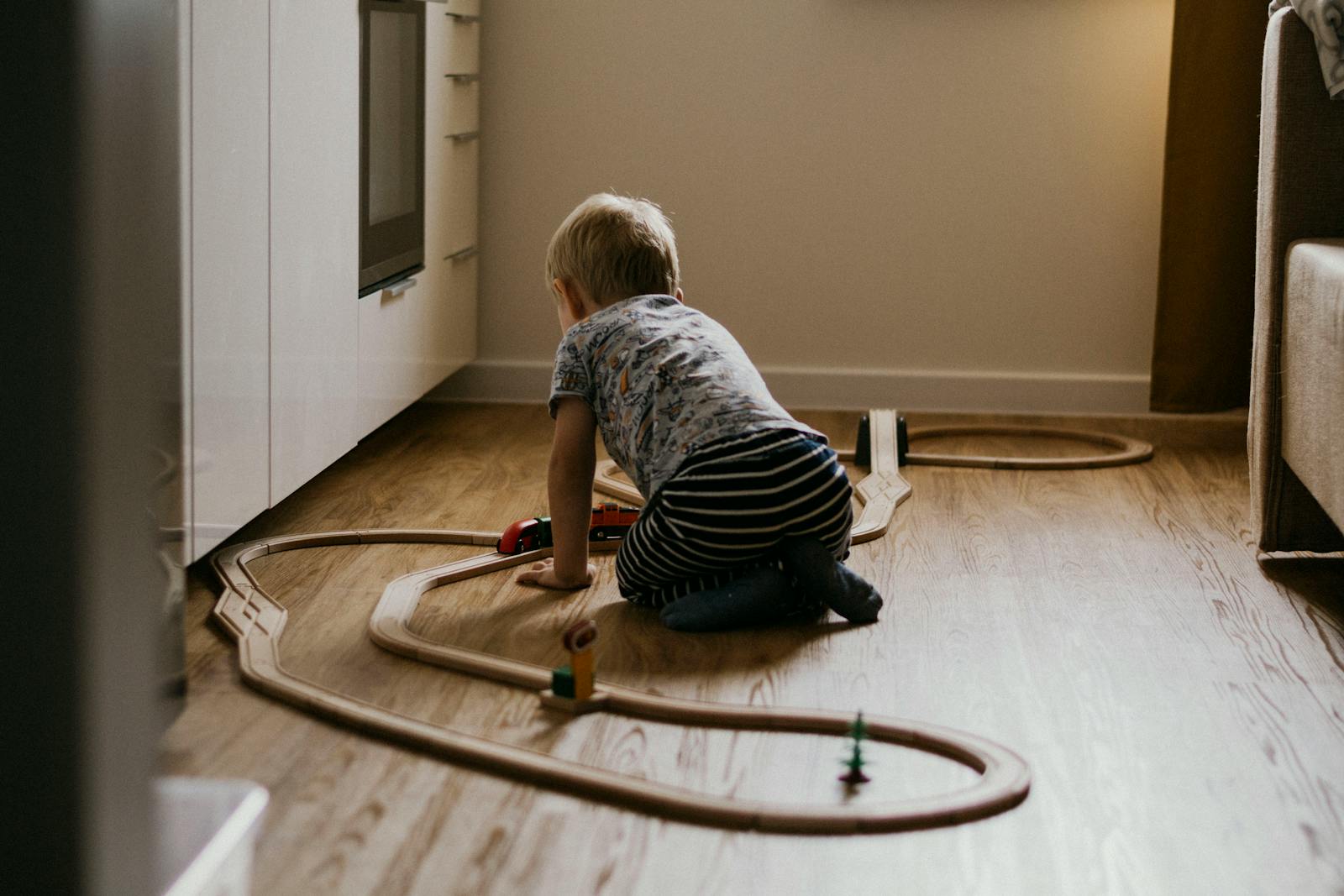 A child pushing a laundry basket across the floor during active play