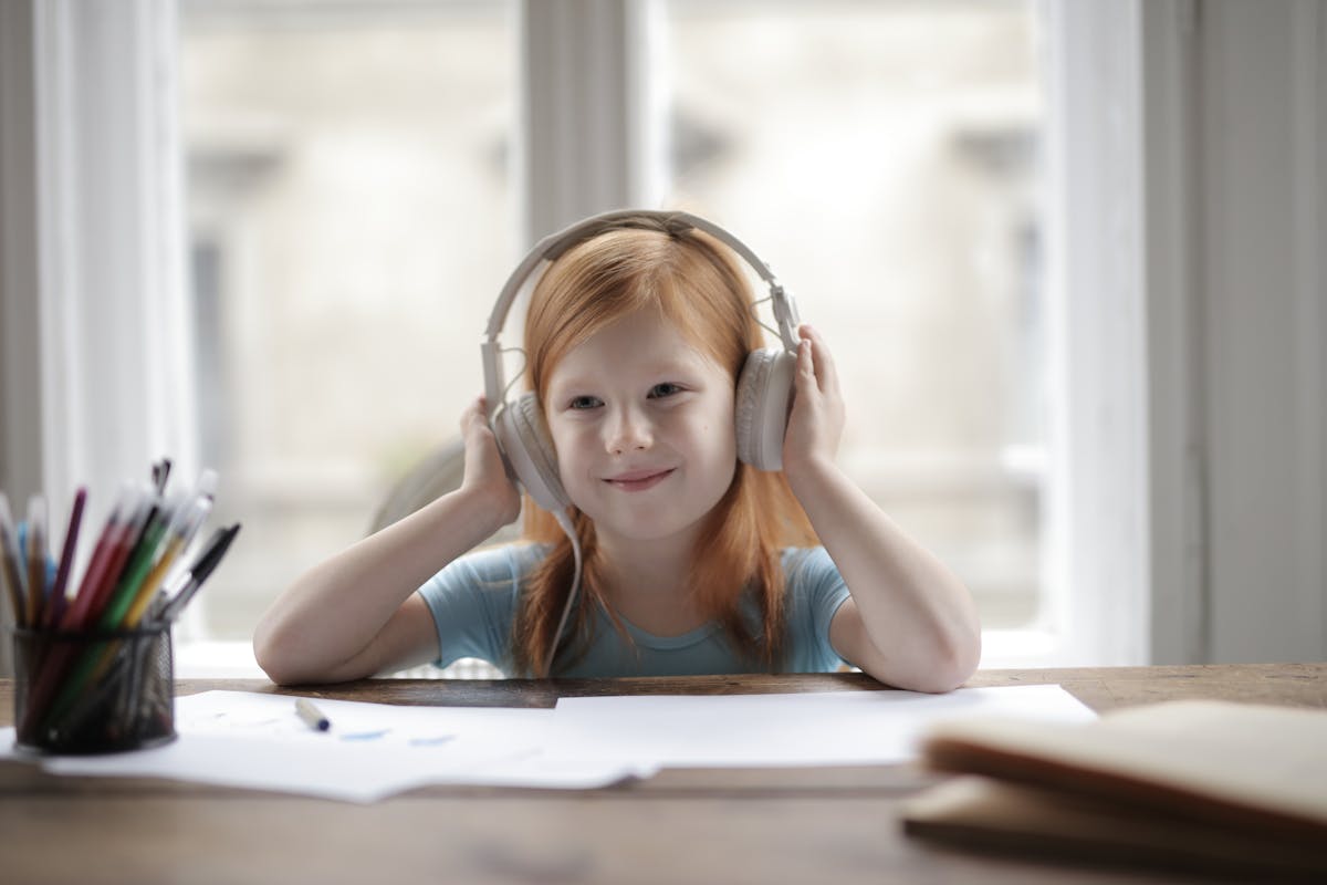 Sensory items including headphones, a weighted lap pad and fidget tools on a table